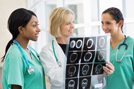 Two nurses examining xray film with doctor